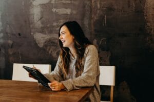 plan manager sitting around table holding tablet