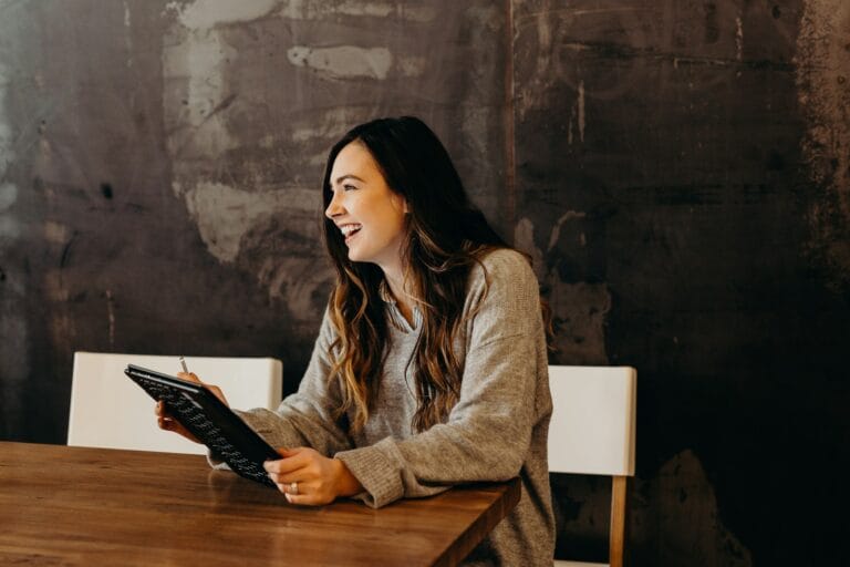 plan manager sitting around table holding tablet