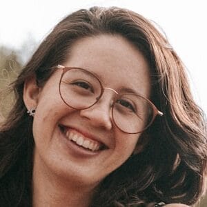 woman in black and red floral spaghetti strap dress smiling