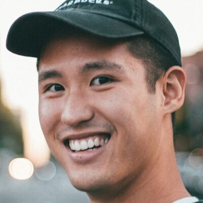 man stranding on straight road photo during daytime