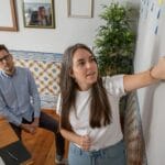 a man and a woman standing in front of a whiteboard