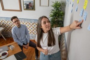 a man and a woman standing in front of a whiteboard